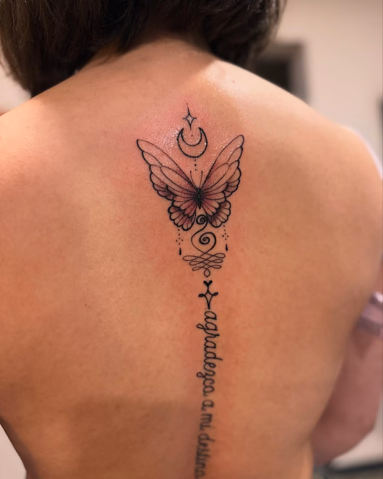 Schmetterling mit Mond, Unalome und Schriftzug in feinen Linien entlang der Wirbelsäule