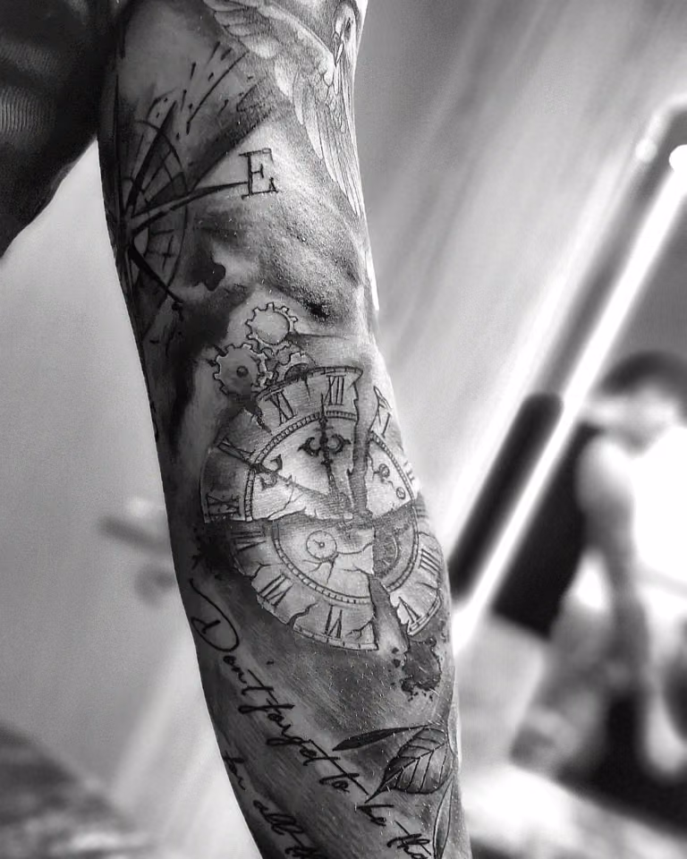 Taschenuhr, Kompass und Schriftzug als Black-&-Grey-Sleeve am Arm