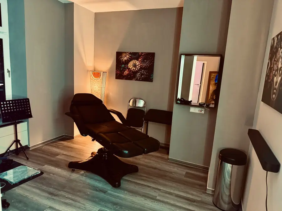 Arbeitsplatz im Studio mit schwarzer Liege und Stehlampe